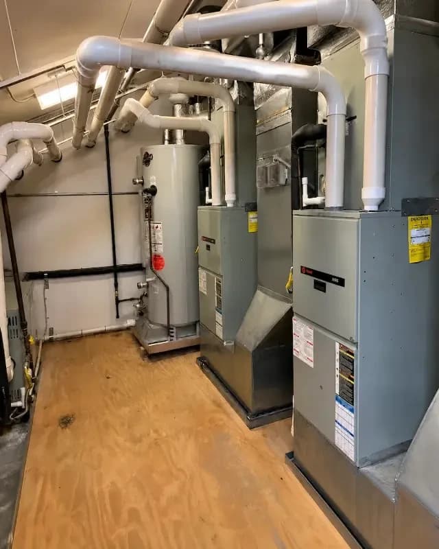 Furnaces and water heater in an equipment room serviced by Turner Mechanical in East Tennessee
